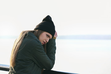Young depressed woman thinking about suicide on bridge
