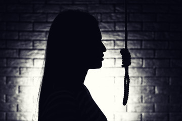 Silhouette of woman with noose on dark background. Suicide concept