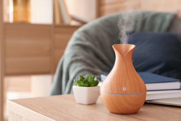 Aroma oil diffuser on table in room - obrazy, fototapety, plakaty