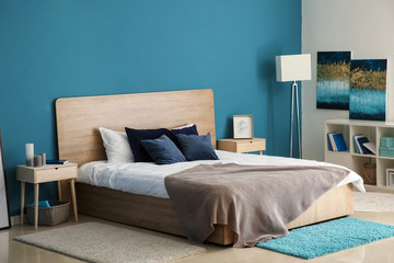 Big comfortable bed in stylish interior of room