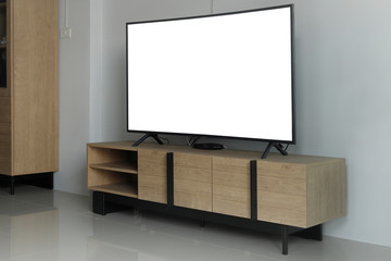 Smart Tv with black glossy screen on console wood in living room.