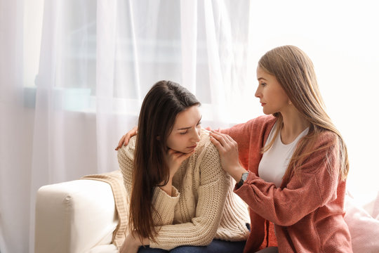 Friend helping young depressed woman at home. Stop a suicide