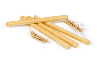 Breadsticks with sesame seeds and wheat ears on white background