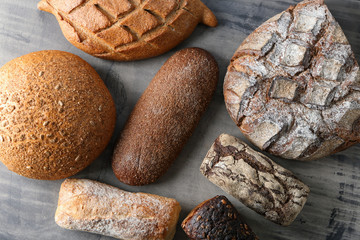 Assortment of tasty bread on grey table