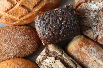 Assortment of tasty bread on grey table