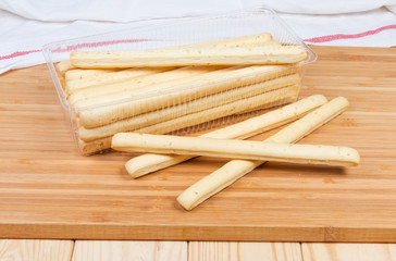 Breadsticks with sesame seeds on a wooden surface