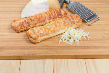 Cheese-stuffed bread sticks, different cheese on wooden cutting board