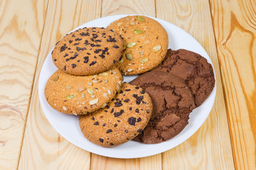 Various drop cookies on white dish on the wooden table