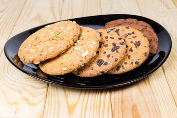 Various drop cookies on black dish on the wooden table