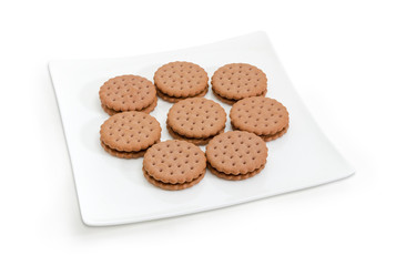 Round sandwich cookies on a white square dish