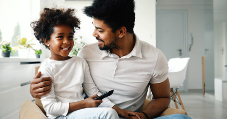 Father and daughter sitting on couch at home