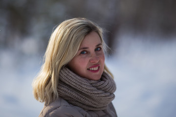 Portrait of a smiling woman in a winter park