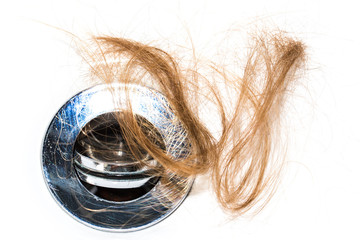 Hair loss on washbasin. Long brown hair on white basin in the bathroom.