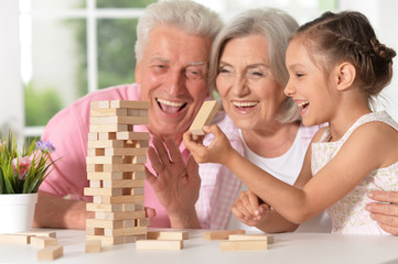 Portrait of grandparents with granddaughter playing together