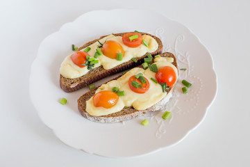Multigrain toast bread with melt gouda or kaseri cheese and small tomatoes and green onion on top 
