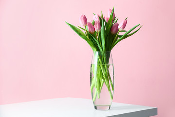Vase with bouquet of beautiful tulips on table