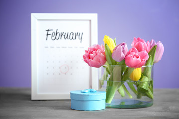 Bouquet of beautiful flowers, calendar and gift box on table