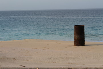 A rusty barrel on the sand