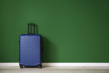 Packed suitcase near color wall