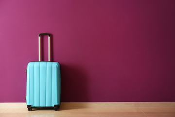 Packed suitcase near color wall