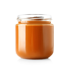 Jar with sweet liquid caramel on white background