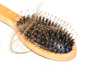 Hair loss on washbasin. Long brown hair with wood brush on white basin in the bathroom.