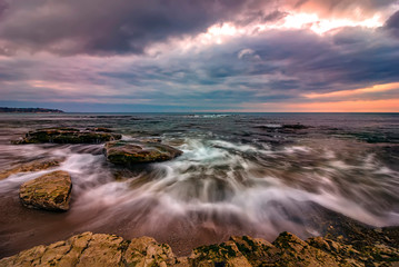 Amazing long exposure seascape with motion blur and flowing waves at the rocks.