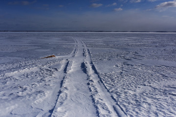 Fototapeta na wymiar road to the horizon on the ice-covered lake