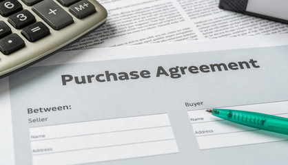 A Purchase agreement with a pen on a desk