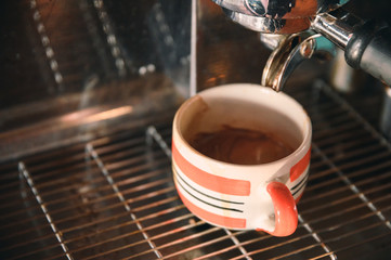 Coffee maker machine grinder pouring coffee in mug