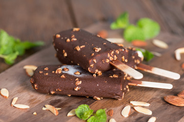 Ice cream covered with chocolate and almonds sticks.