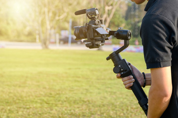 Professional videographer with camera on gimbal stabilizer for taking