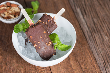 Ice cream covered with chocolate and almonds sticks in ice.