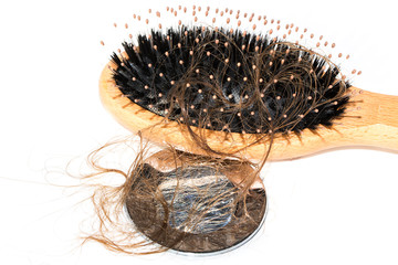 Hair loss on washbasin. Long wet brown hair with wood brush on white basin in the bathroom.