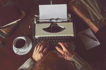 Young man writing on old typewriter.