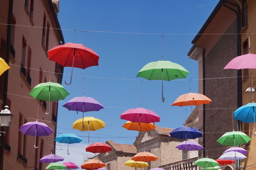 Fototapeta na wymiar Giuseppe Mazzini street with hanging umbrellas, Ferrara, Italy