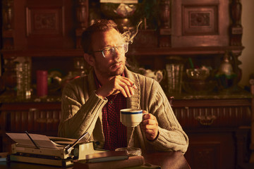 Young man writing on old typewriter.