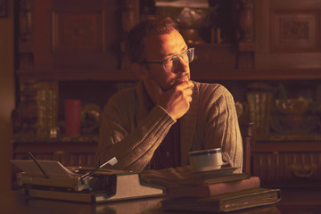 Young man writing on old typewriter.