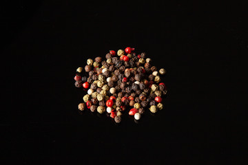 Close up view on black pepper isolated on black background. Spices. Useful image for desgn with copy space