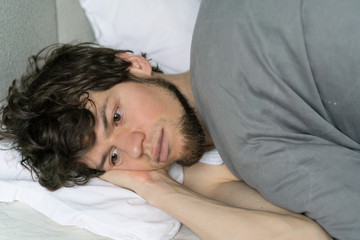 Fototapeta na wymiar Depressed man wake up on bed early in the morning.