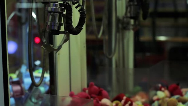 Crane Toy Grabbing Machine, Claw Crane Machine Grabbing a Toy. Close Up.