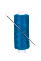 Blue spool of thread with a sewing needle on a white isolated background