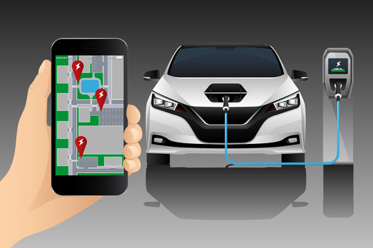 Hand with mobile phone on the background of a charging electric car. On the screen is a map with the location of the charging stations.