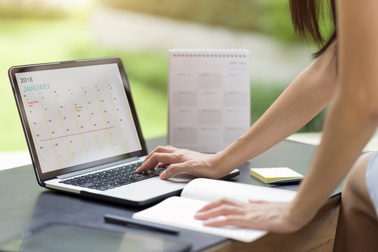 Woman planning agenda and schedule using calendar event planner. Woman hands using plan to vacation on computer laptop. Calender planner organization management remind concept.