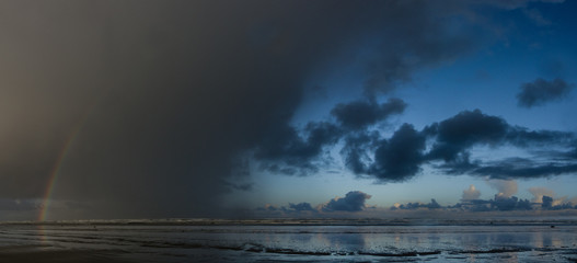 Approaching Storm - Rainbow appears in an approaching storm along the ocean. Ocean Shores, Washington.