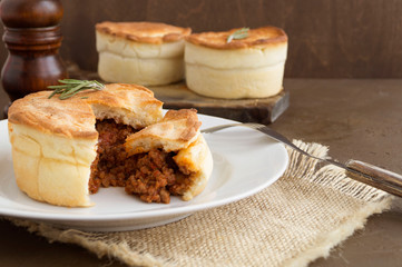 Australian meat pie on wooden table close-up with copy space, rustic style