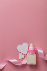 Baby bottle on a pastel pink background. New baby arrival