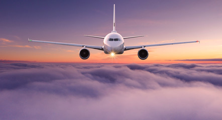 Fototapeta premium Odrzutowiec samolotu komercyjnego latające nad chmury dramatyczne w pięknym świetle słońca. Koncepcja podróży.