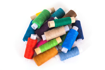 Multicolored sewing threads on white background