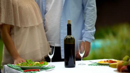 Couple serving table before date in country house, home-made wine traditions